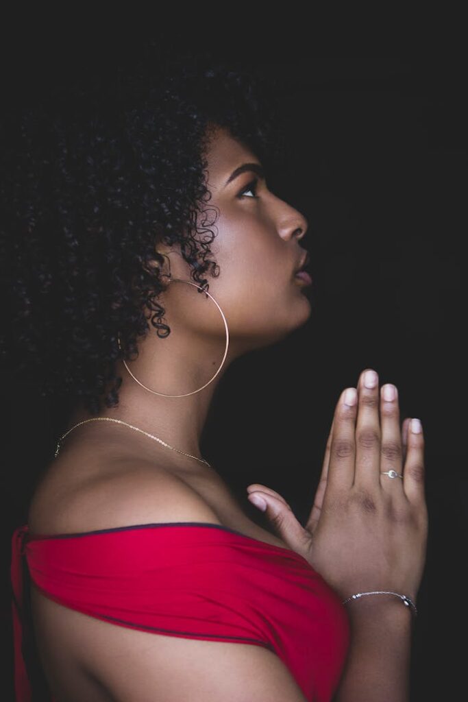 Profile view of a woman praying, creating a serene and contemplative mood.